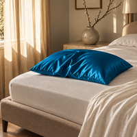 Taie d'oreiller en soie de mûrier bleu paon sur un lit, dans une chambre élégante